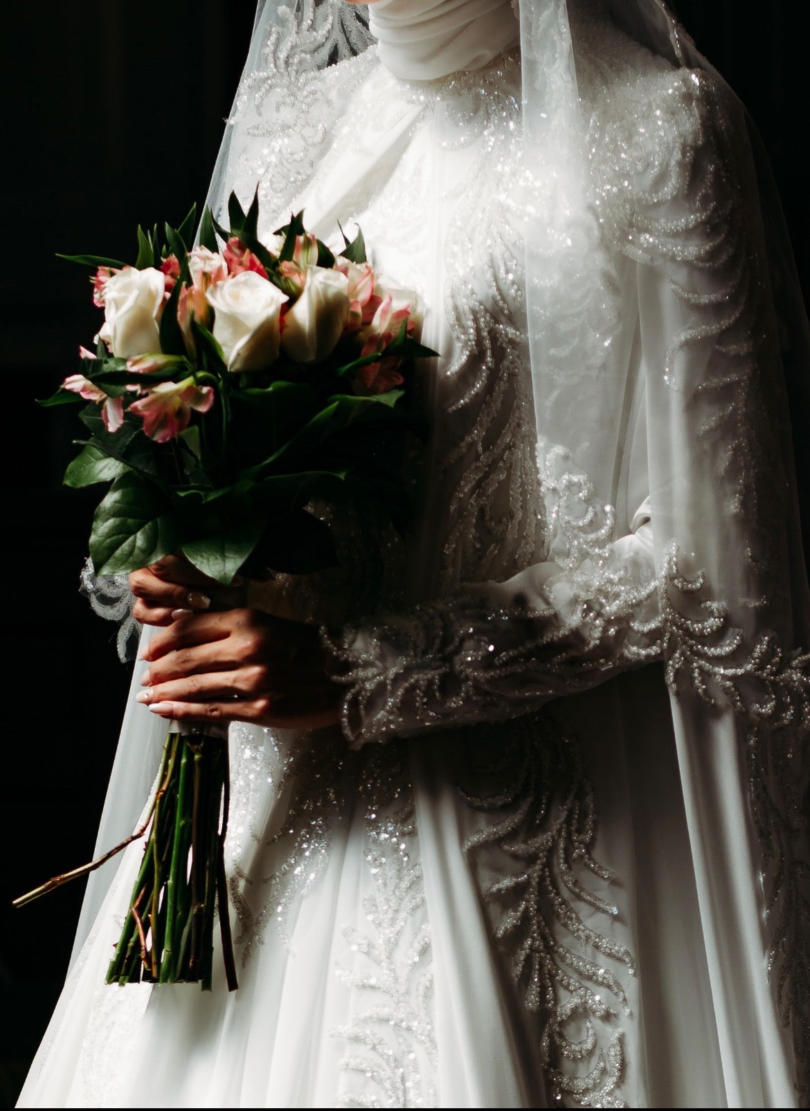 Bride holding a bouquet of flowers with a dark background