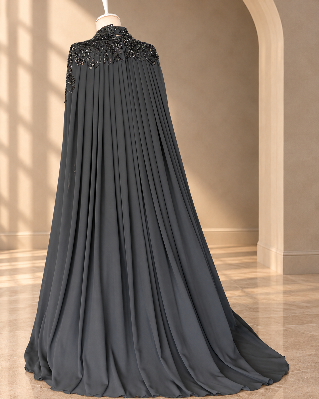 Selma charcoal grey gown from the back, showing the full pleated cape and train