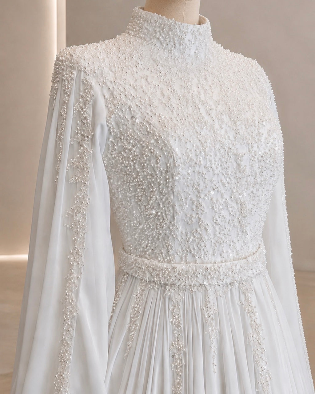 Elegant white dress with intricate beading on a mannequin against a neutral background
