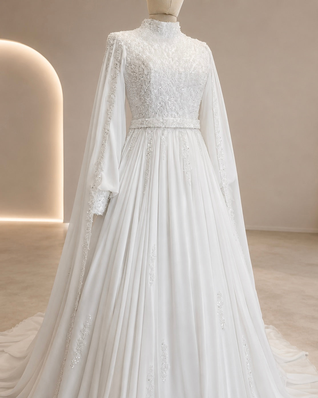 White wedding dress with long sleeves on a mannequin against a neutral background